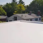 Flat white PVC roofing membrane installed on a residential building, showcasing energy-efficient roofing solution in Pittsburgh's residential area.