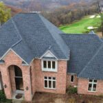 Residential home with a high-performance asphalt roof, showcasing quality craftsmanship and design, set against a green landscape, relevant to Malick Brothers Exteriors' roofing services in Pennsylvania.