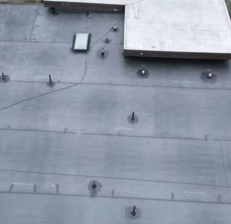 Flat commercial roof with membrane installation, featuring ventilation fittings and a skylight, relevant to roofing solutions in Pittsburgh.