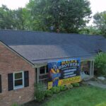 Residential roofing project by Malick Brothers Exteriors, showcasing a completed roof and promotional banner for metal roofing services in Pittsburgh.
