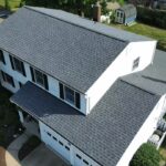 Aerial view of a residential roof featuring dark shingles, highlighting the craftsmanship of a roofing contractor in Pittsburgh.