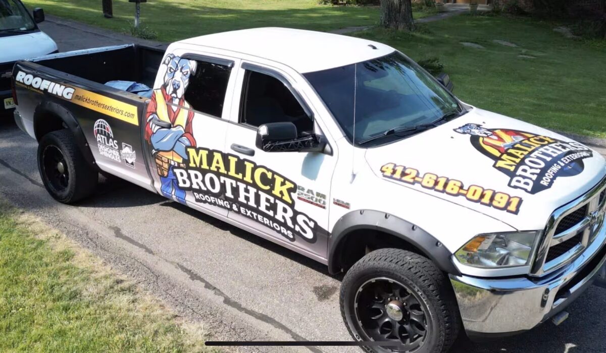 Malick Brothers Exteriors branded truck parked on a residential street, showcasing roofing services and contact information, emphasizing local expertise in Pittsburgh roofing solutions.
