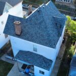 Aerial view of a residential home in Pennsylvania with a newly installed asphalt shingle roof, showcasing proper roofing techniques and materials relevant to homeowners considering roof insurance claims.