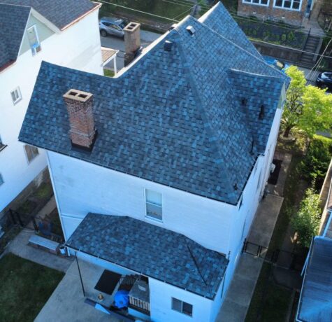 Aerial view of a residential home in Pittsburgh featuring a newly installed blue-gray shingle roof, showcasing quality roofing craftsmanship by Malick Brothers Exteriors.