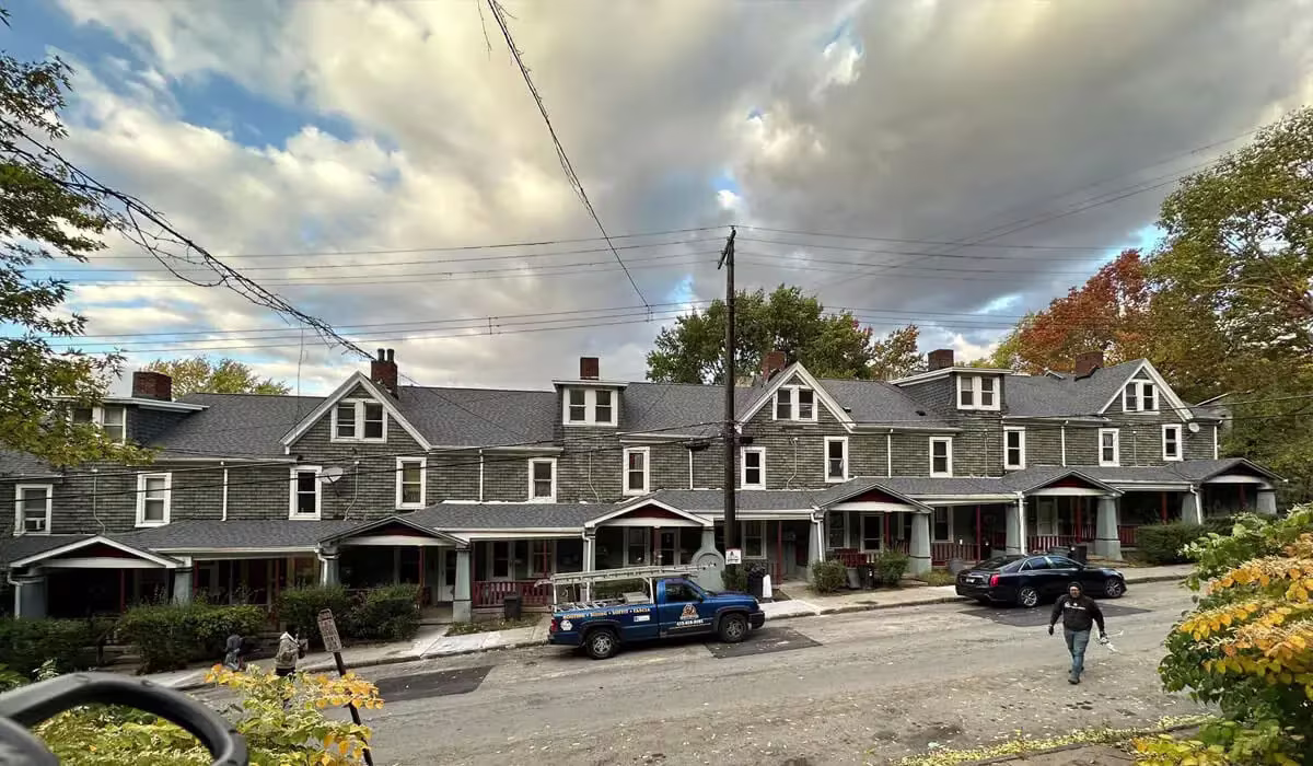 Commercial building in Pittsburgh with a dark gray roof and surrounding seasonal foliage.