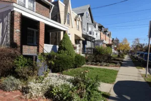Row of historic homes in Squirrel Hill, Pittsburgh, showcasing varied architectural styles, well-maintained landscaping, and proximity to sidewalks, emphasizing the importance of roofing solutions for older homes.
