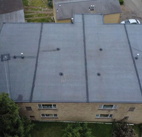 Aerial view of a flat commercial roof with ventilation units, showcasing the surface condition relevant to roofing maintenance and repair services by Malick Brothers Exteriors.