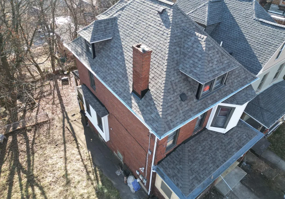 Aerial view of a residential home in Pittsburgh featuring a newly installed asphalt shingle roof, showcasing the roofing style and color options relevant to GAF, Atlas, and Owens Corning brands.