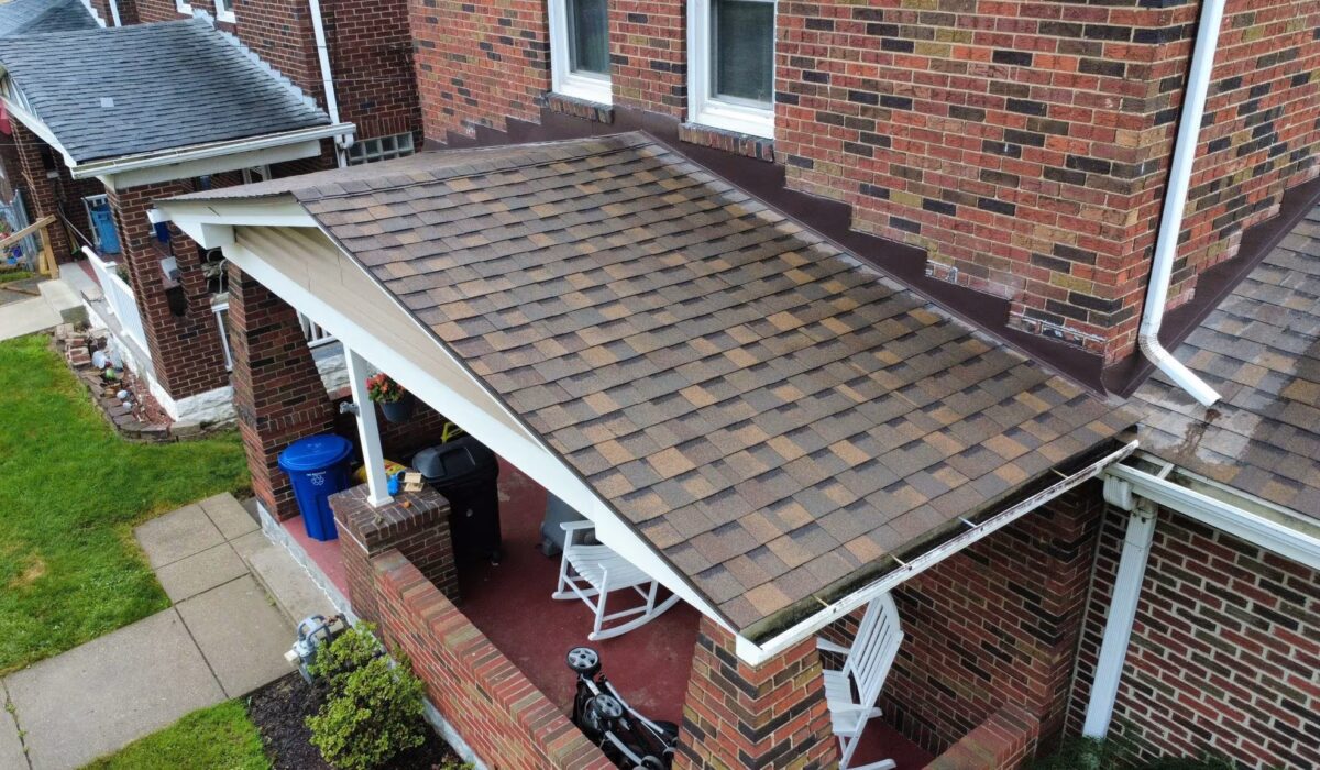 Roof shingles on a residential home in Pittsburgh, showcasing a well-maintained roof with a porch area, highlighting the importance of roof integrity in preventing leaks and costly repairs.