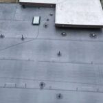 Flat roofing system with drainage features and skylight, showcasing durable materials for Robinson Township's climate-specific roofing solutions.