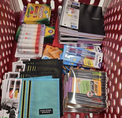 Basket filled with school supplies including notebooks, markers, pens, and folders, symbolizing community support for back-to-school initiatives by Malick Brothers Exteriors.