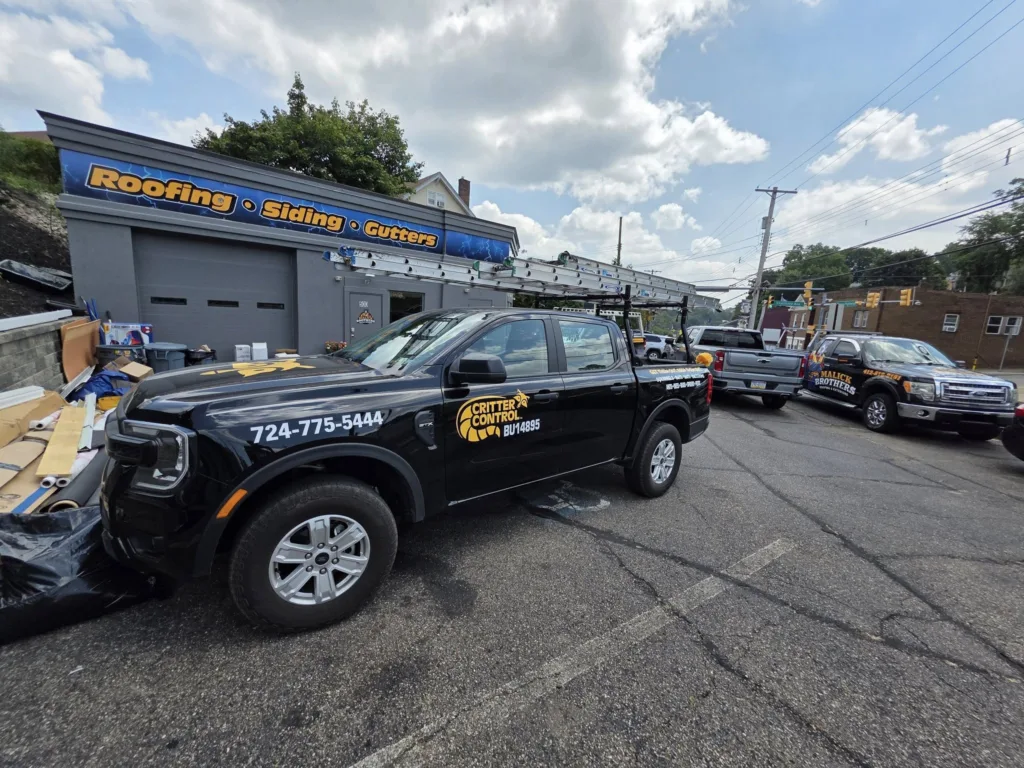 Critter Control service vehicle parked outside Malick Brothers Exteriors, showcasing community partnership for local outreach initiatives.
