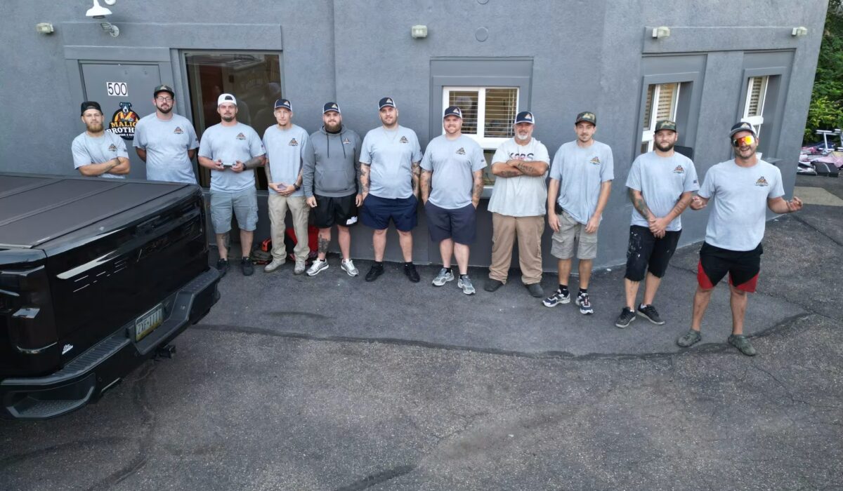 Malick Brothers Exteriors team standing outside their office in Pittsburgh, showcasing commercial roofing expertise and local contractor presence.