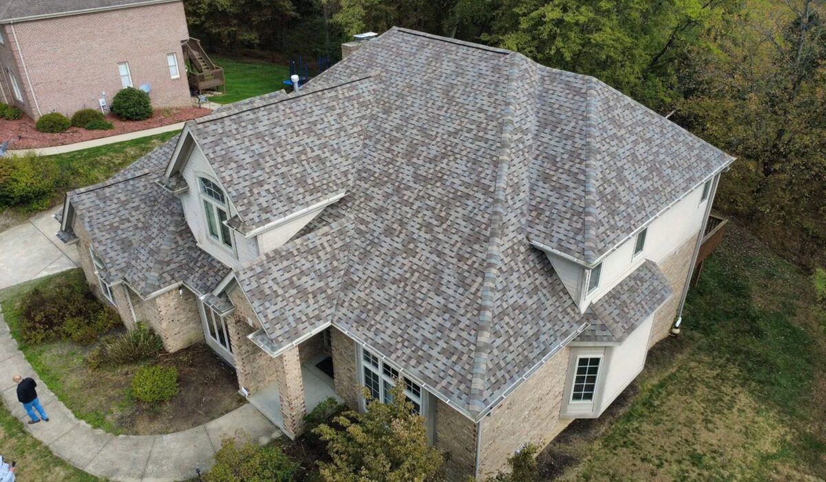 Aerial view of a residential roof showcasing a new asphalt shingle installation, emphasizing quality roofing work essential for home protection and maintenance.