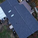Aerial view of a residential roof with skylights, showcasing the condition and materials relevant to roof maintenance and insurance considerations.