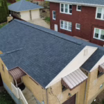 Aerial view of a residential building showcasing a new roof installation, emphasizing roofing materials relevant for homeowners considering gutter systems and exterior home improvements.
