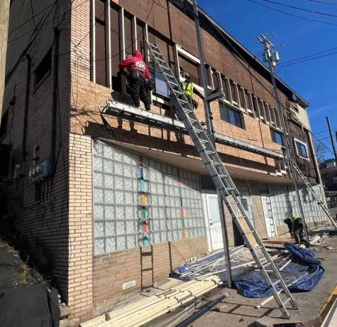 Malick Brothers crew installing siding from a lift on a multi unit building