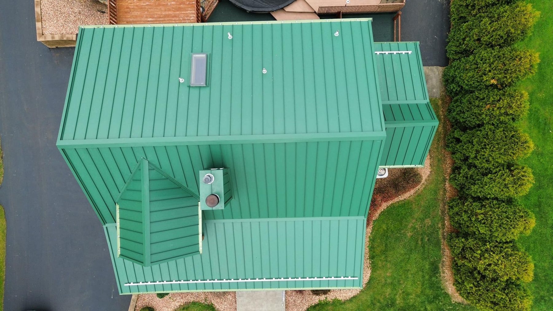 Top down view of green standing seam metal roof panels installed by Malick Brothers Exteriors