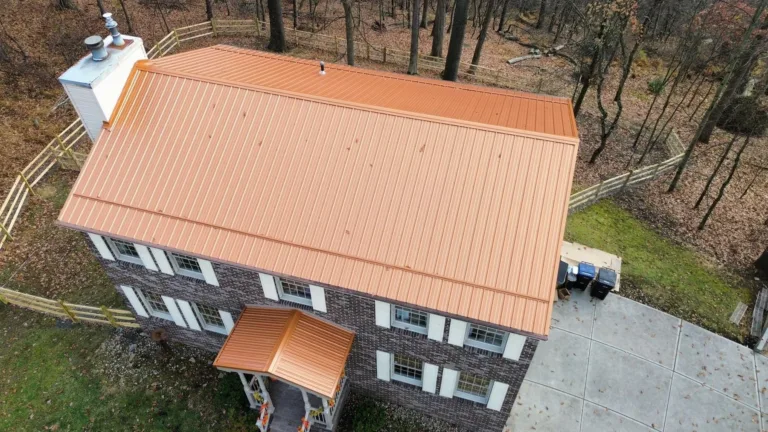 Copper colored metal roof installed by Malick Brothers Exteriors on a brick colonial