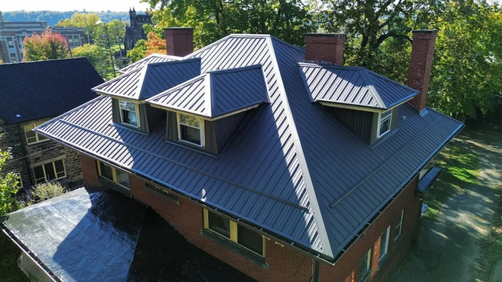 Charcoal standing seam metal roof installed by Malick Brothers Exteriors on a brick home