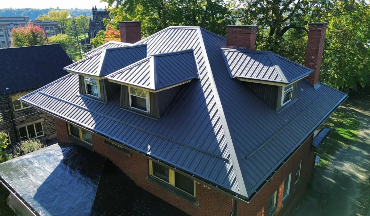 Charcoal standing seam metal roof installed by Malick Brothers Exteriors on a brick home