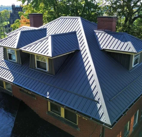 Charcoal standing seam metal roof installed by Malick Brothers Exteriors on a brick home