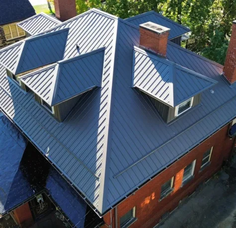 Standing seam metal roof with dormers and chimneys by Malick Brothers Exteriors