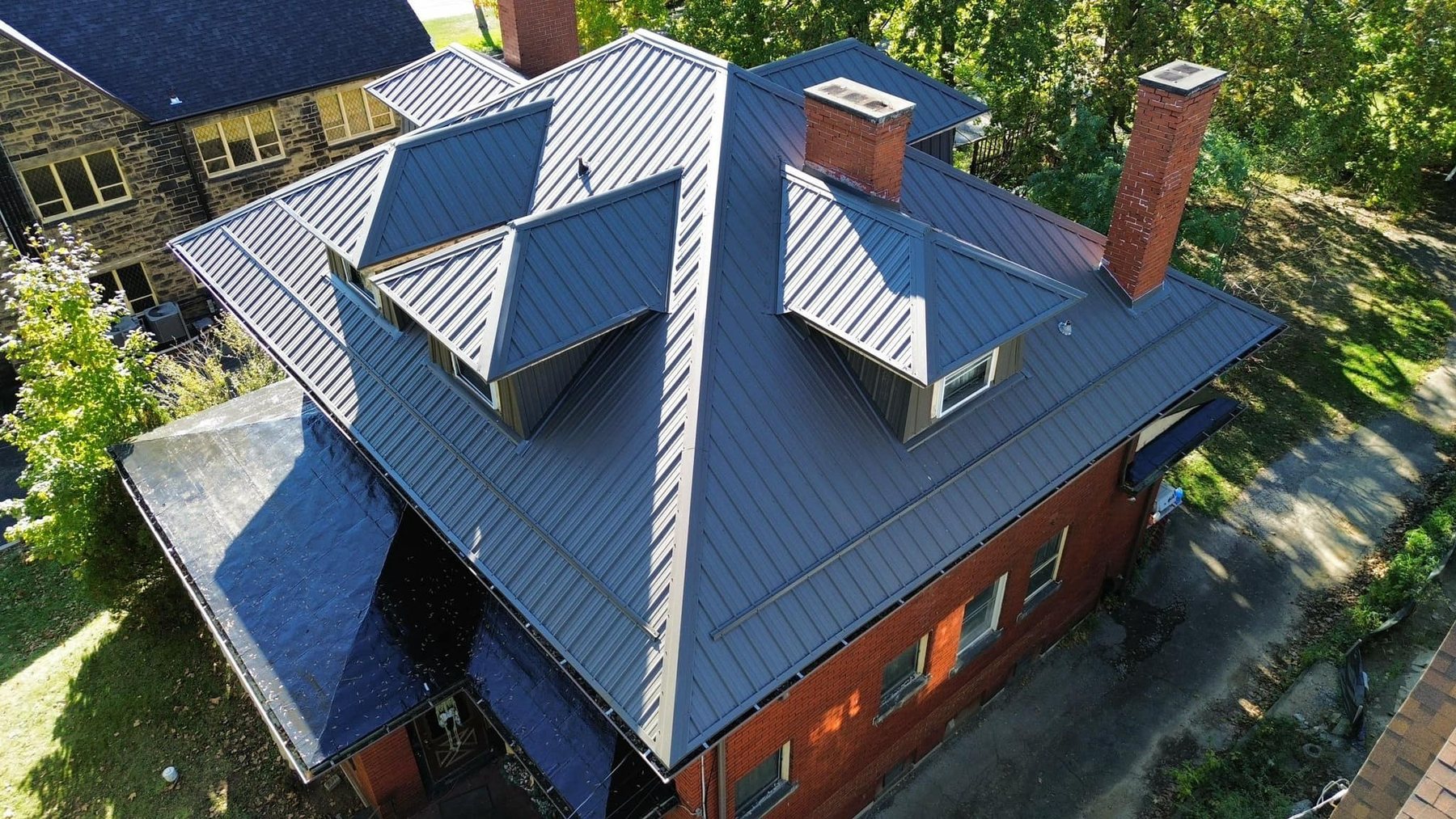 Standing seam metal roof with dormers and chimneys by Malick Brothers Exteriors