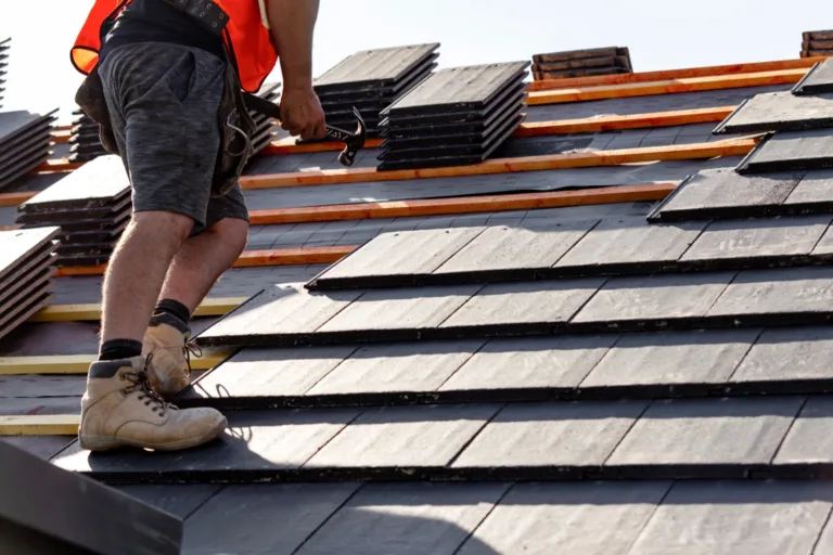 Roofer setting new slates on a roof